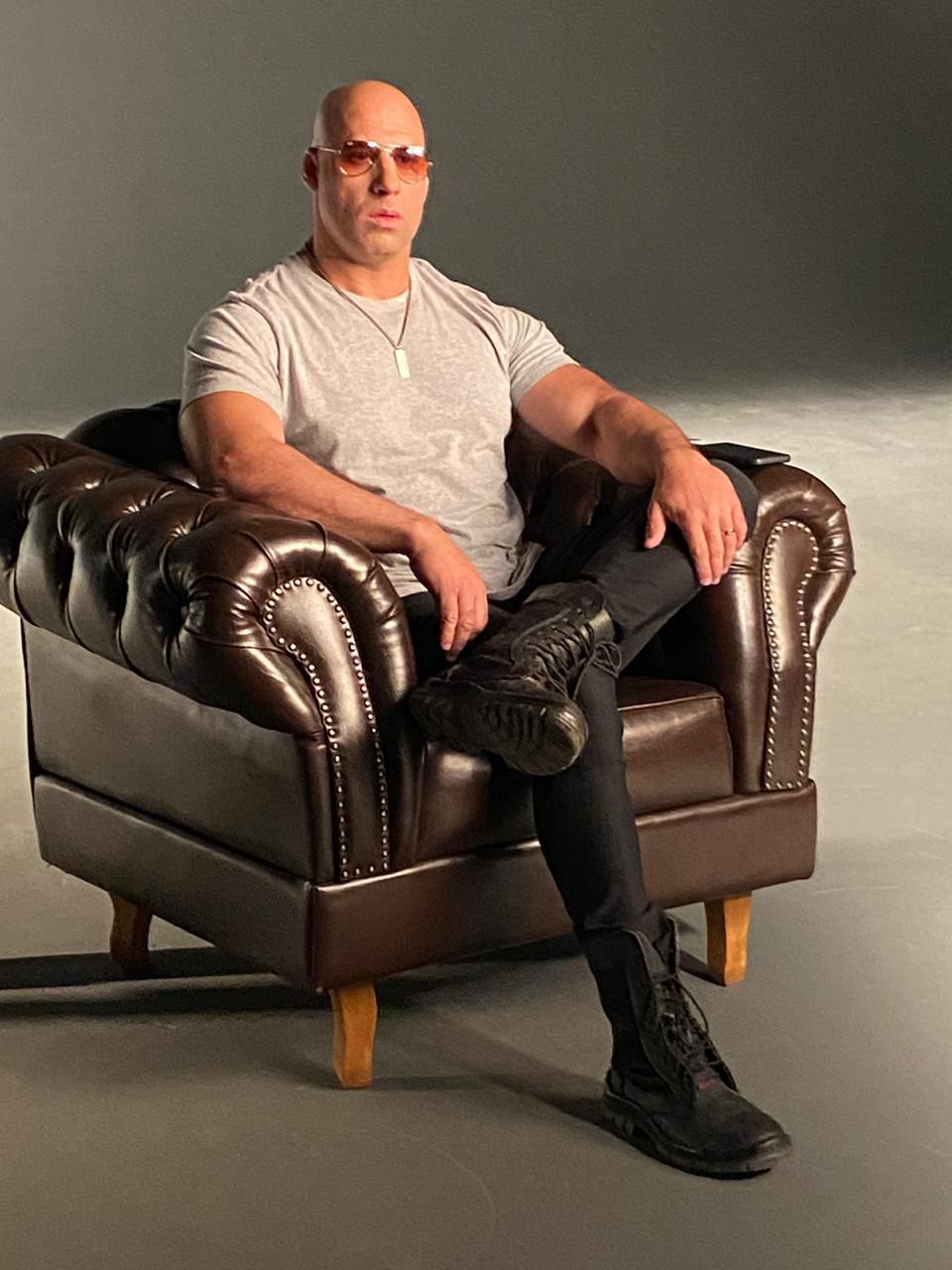Vin Diesel Brasileiro sentado em poltrona de couro durante ensaio publicitário