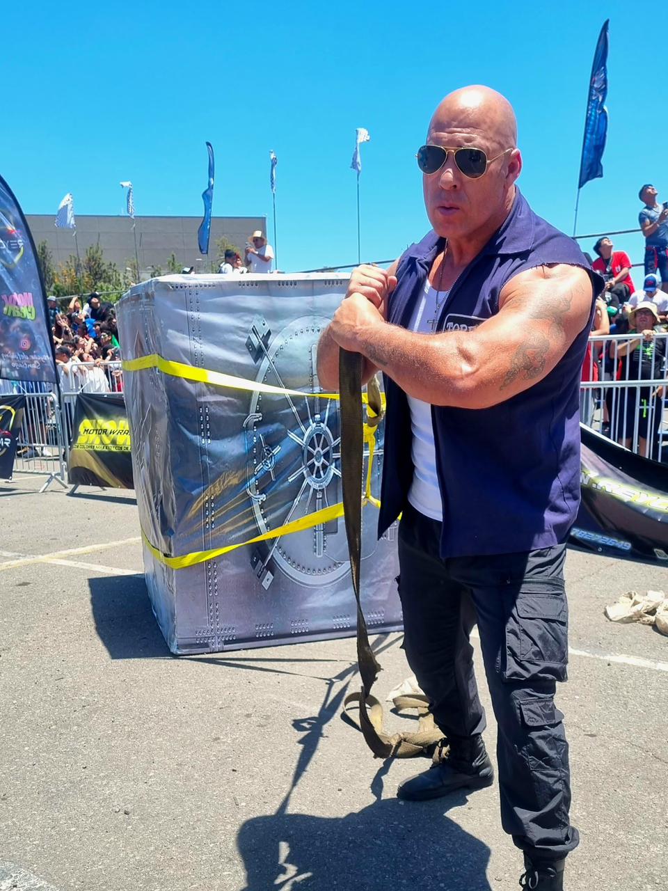 Vin Diesel Brasileiro carregando o cofre de Velozes e Furiosos em evento automotivo lotado
