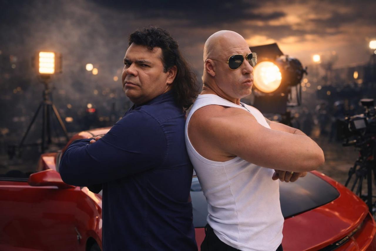Vin Diesel Brasileiro encostado em carro esportivo vermelho ao entardecer, cena cinematográfica
